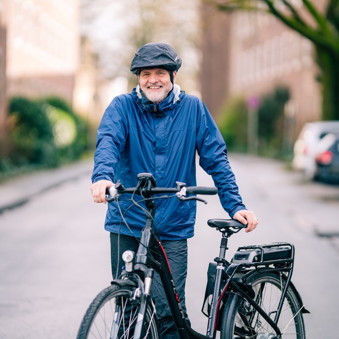 Stefan Rütsch steht mit seinem Fahrrad auf der Straße. (vergrößerte Bildansicht wird geöffnet)