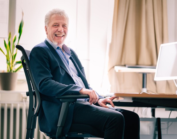 Michael Hechsel sitzt an seinem Schreibtisch.