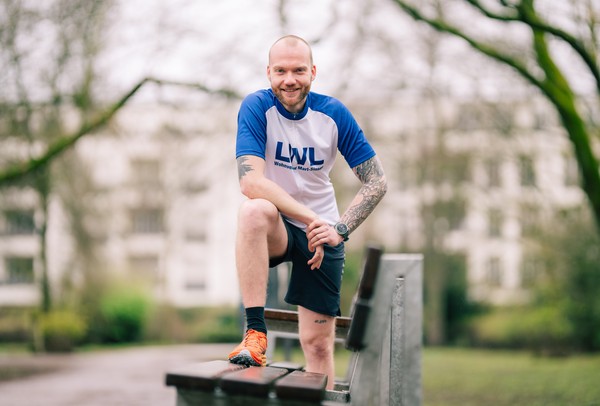 Nils Wehrenbrecht steht mit einem Bein auf der Bank und lehnt sich etwas nach vorne.