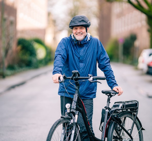 Stefan Rütsch steht neben seinem Fahrrad auf der Straße.