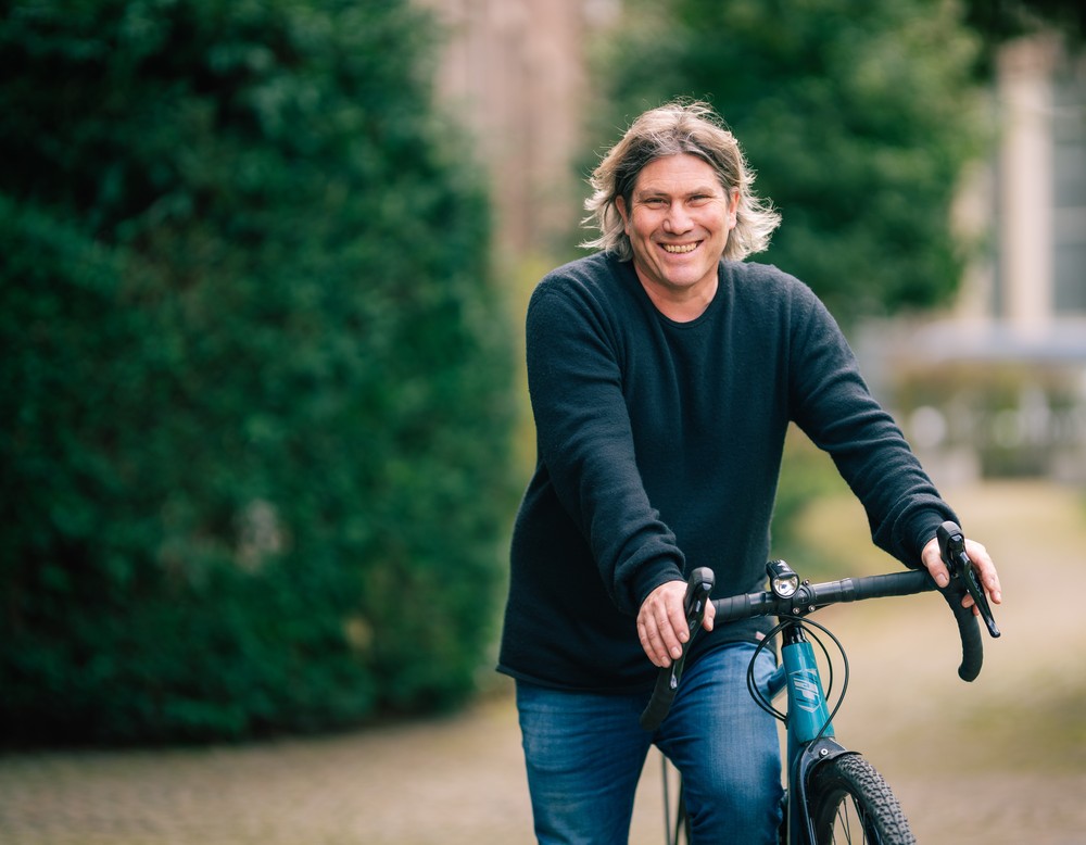 Stefan Gilles schiebt sein Fahrrad durch den Park.